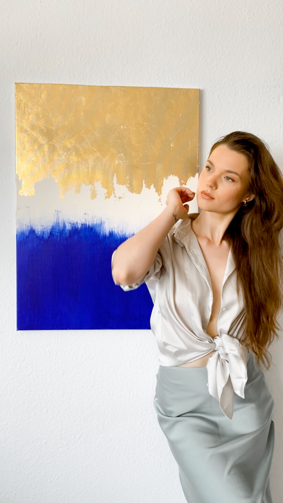 Lorena Krüner standing in front of her artwork "Gold & Blue"